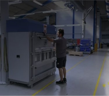 man in productieomgeving bedient een grote Mil-tek balenpers